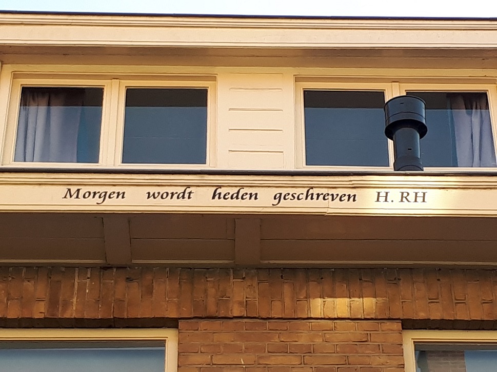 Foto van een dakgoot met de tekst: Morgen wordt heden geschreven, H. RH.
